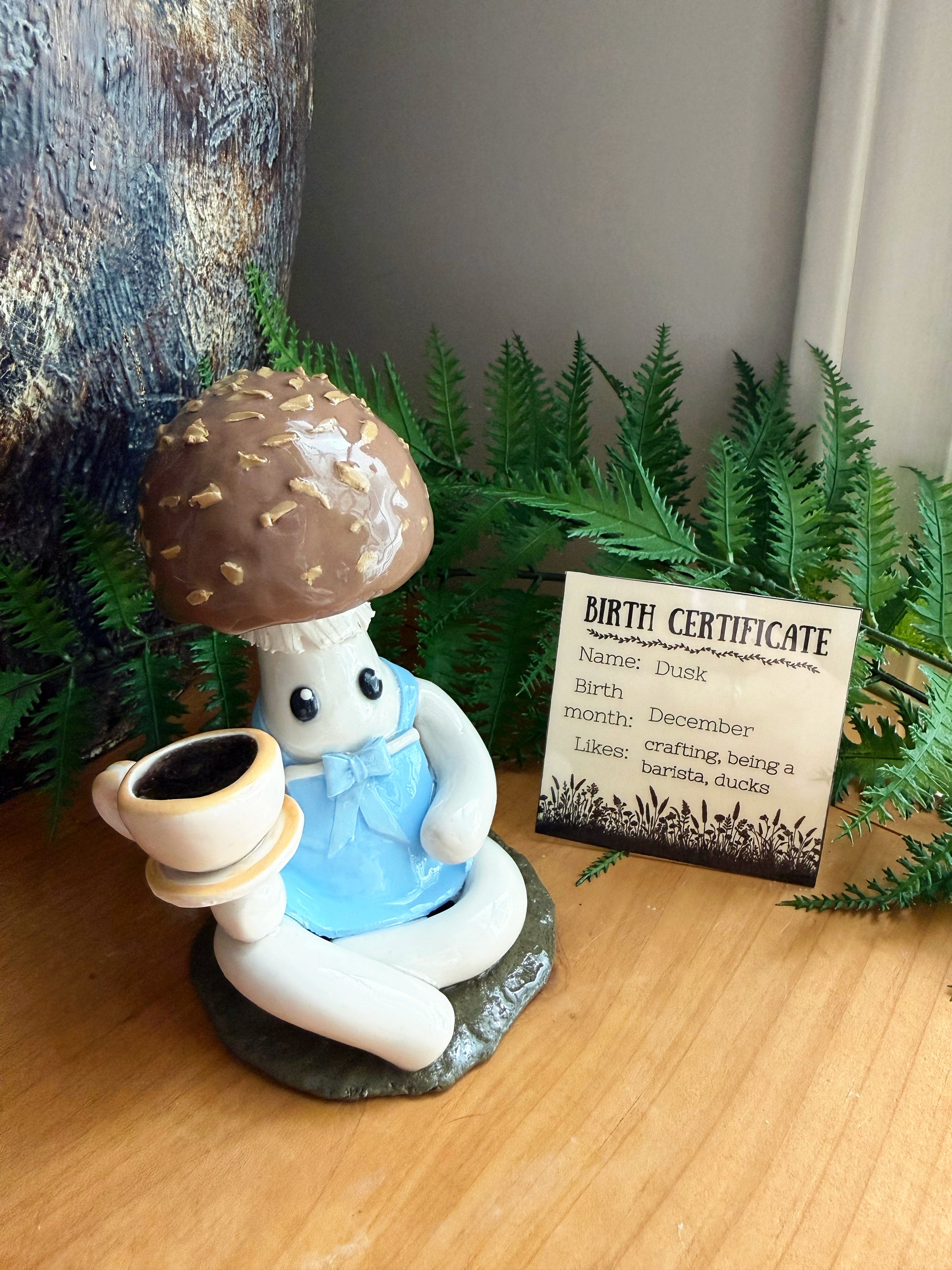 Figurine of a mushroom with a 'birth certificate' in the background